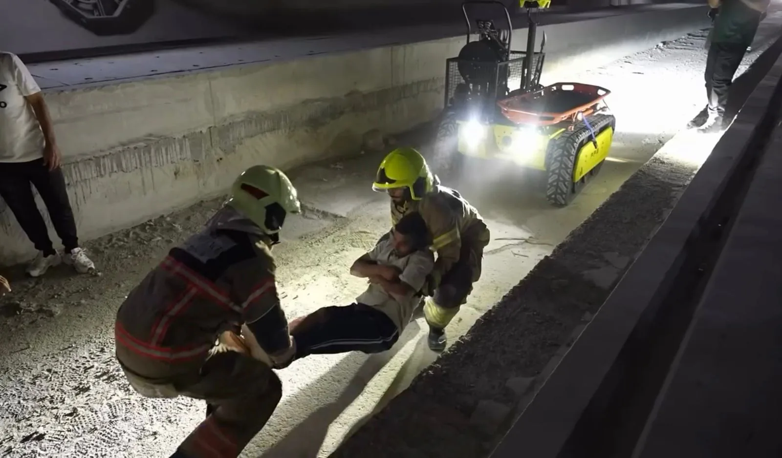 Firefighters carrying a casualty, robot behind