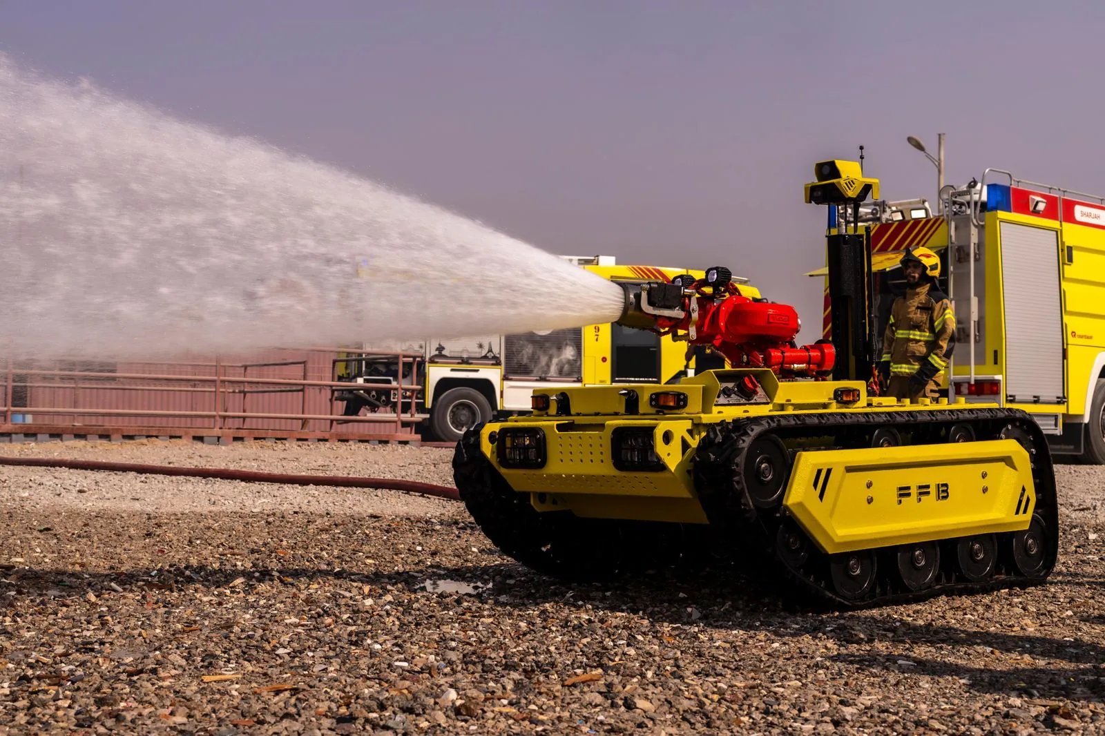 Robot spraying water with a firefighter on the engine