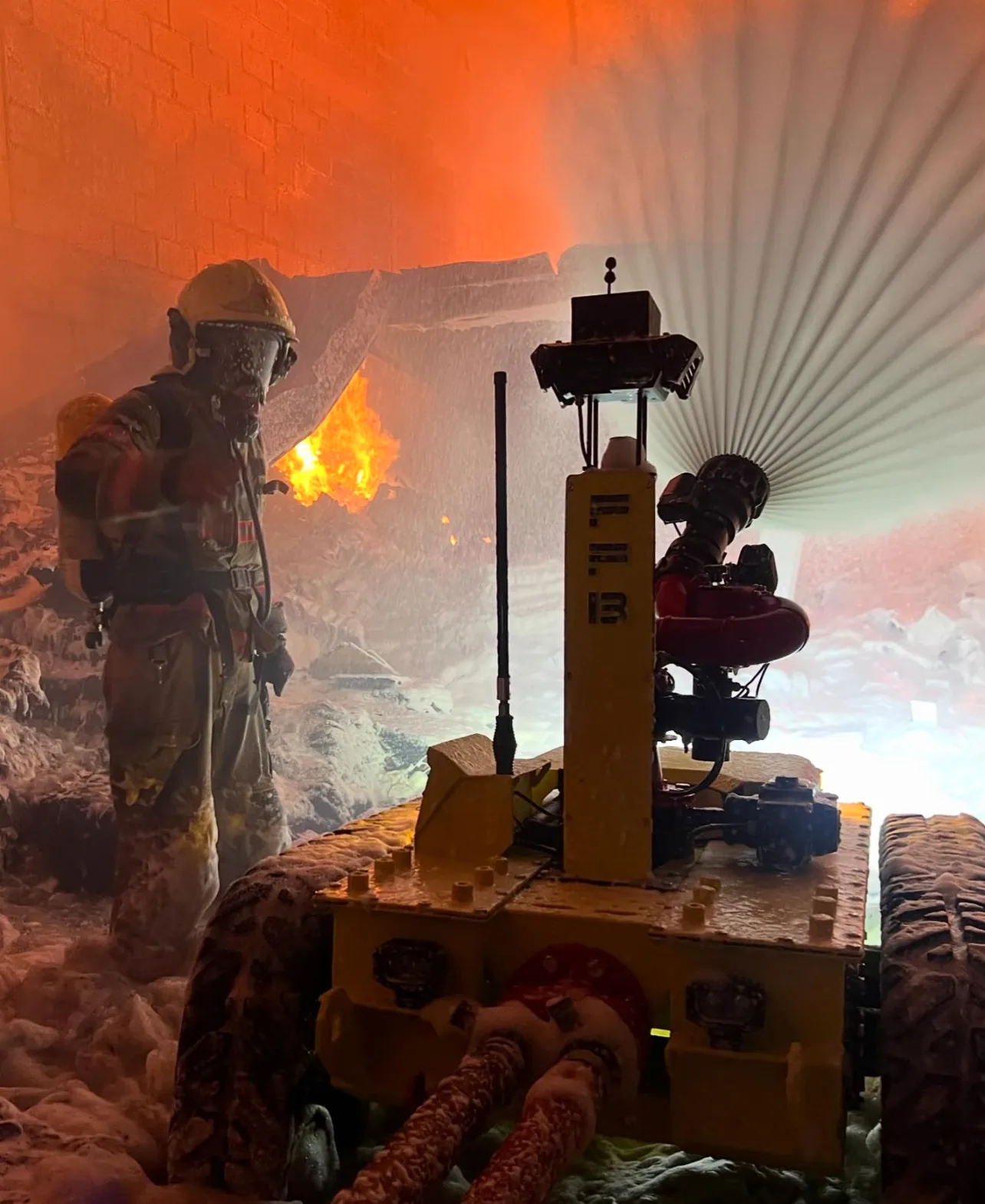 Firefighter and robot in a live fire